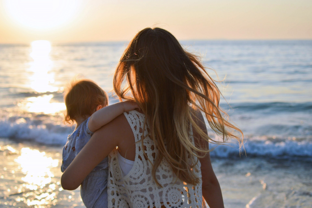 Woman with baby looking at the sea
