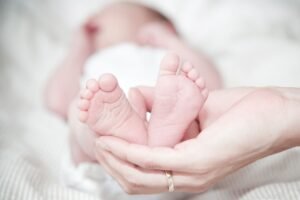 νεογέννητο με εστίαση στα πατουσάκια που κρατάει η μαμά